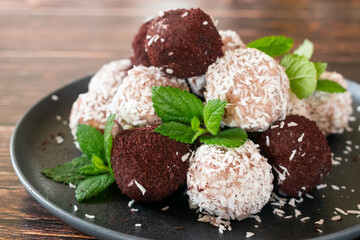 Acai bliss balls, energetic balls with açai powder and coconut, decorated with mint leaves