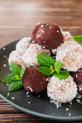 Acai bliss balls, energetic balls with açai powder and coconut, decorated with mint leaves