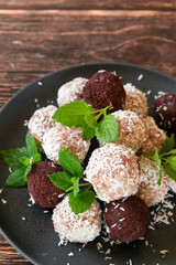 Acai bliss balls, energetic balls with açai powder and coconut, decorated with mint leaves