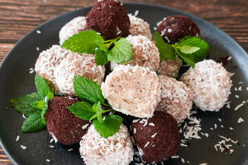 Acai bliss balls, energetic balls with açai powder and coconut, decorated with mint leaves