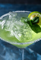 Glass of cold daiquiri cocktail on color background, closeup