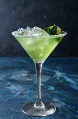 Glass of cold daiquiri cocktail on color background