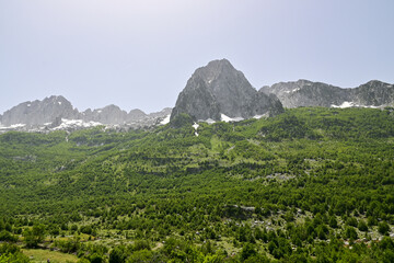 Blick auf das Gebirge mit schneebedeckten Berge im Nationalpark Theth in Albanien, im Sommer bei...
