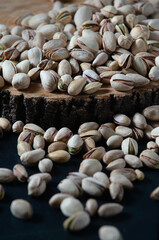 Pistachio ready, laid out on a tree, close-up. Dark background, vertical orientation.