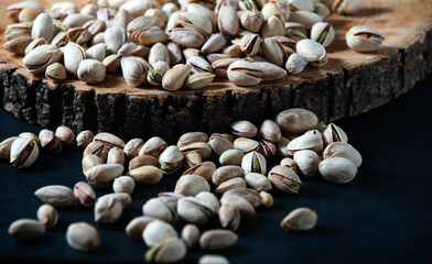 Pistachio ready, laid out on a tree, close-up. Dark background, horizontal orientation.