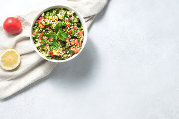 Eastern dish, salad tabouleh, with boiled bulgur, with herbs, tomatoes, lemon, dressed with olive...