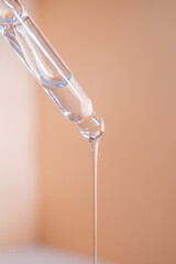 A drop of cosmetic oil falls from the pipette