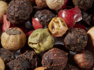 Close-up image of black pepper on a white background, the view above