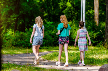 Fototapeta premium Three girls walk in the summer Park 