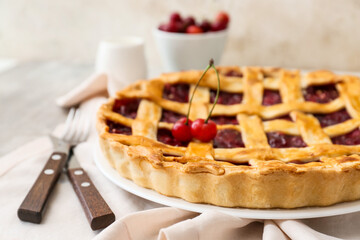 Plate with tasty cherry pie on light table, closeup