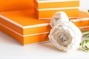 Close up of DYellow boxes with peony flower on the table. Making gift concept.