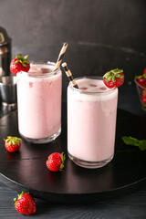 Glasses of strawberry Pina Colada cocktail on dark background