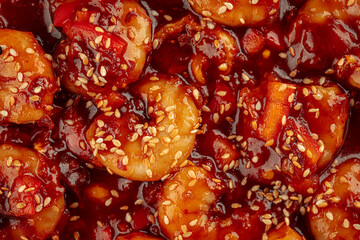 Shrimp with sweet sauce and sesame seeds dish on a wooden background