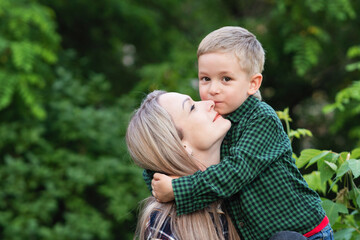 Portrait of nice young mother with pleasure spending time with precious son in Backyard. Vacation....