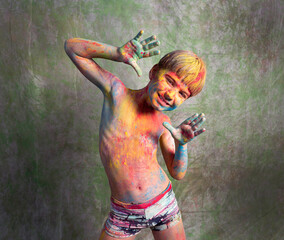 A multicolored portrait of a little boy with festive paints on his body.