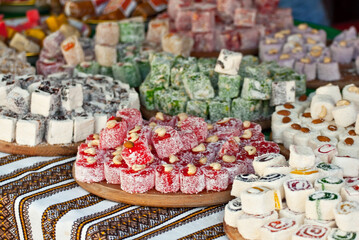Turkish national sweets are sold at the fair. Multi-colored Asian desserts stacked on the table. Rahat lokum in bulk is sold at the festival.