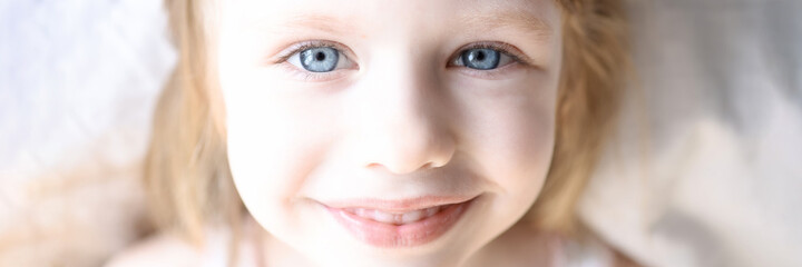 Portrait of little smiling girl with blue eyes