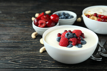 Concept of tasty breakfast with yogurt on wooden table