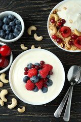 Concept of tasty breakfast with yogurt on wooden table