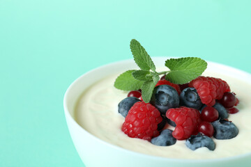 Concept of tasty breakfast with yogurt on mint background