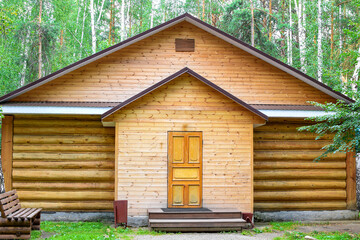 Fototapeta na wymiar Wooden house in the forest for relaxation. Wooden hut in a pine forest.