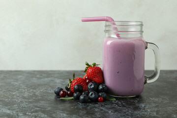 Smoothie and ingredients on black smokey table