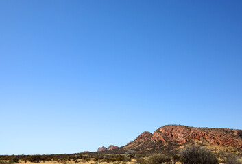 The stunning MacDonnell Ranges, outside Alice Springs, Northern Territory, Australia.  With long roads and open plains with distant mountains.
