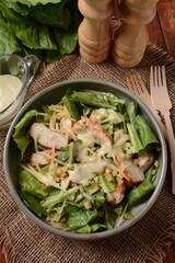 Caesar Salad with grilled chicken, Cheese and Croutons with lettuce, on plate.  Grilled chicken breasts and fresh vegetables in plate.