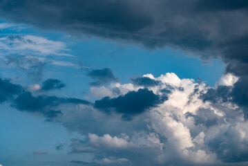 Dramatic sky of cumulus and cirrus clouds. Clouds white and dark gray in the shadows.