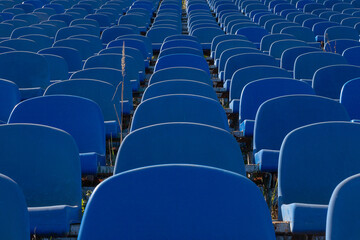 Blue plastic chairs stand in rows in the old stadium