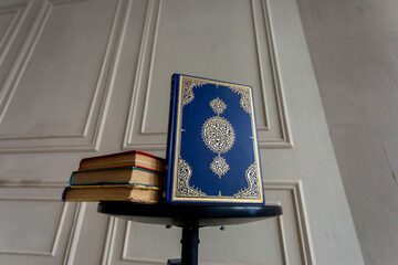 The Qur'an is the holy book in Islam on the table with another books