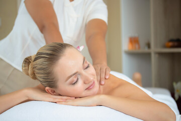 Attractive beautiful girl relax during a back massage on massage bed in spa salon. Spa aroma therapy and massage treatments concept.