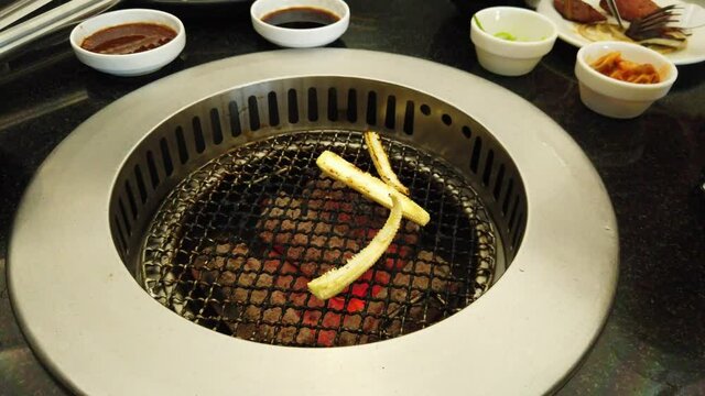 Young Corn sliced in length so they can be grilled and cooked easily, spoon and fork moving as someone is eating.