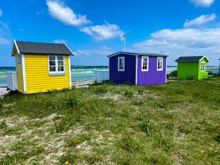 Small colorful houses under the sun at the beach on the island of Aero in Denmark during a summer...