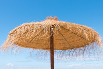 sunshade made of straw, blue sky background