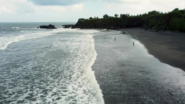 Fly around black sand Bailan beach before storm in Bali. High quality 4k aerial footage
