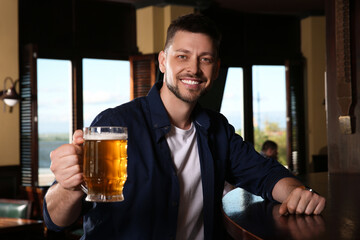 Man with glass of tasty beer in pub