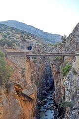 Fototapeta premium Very narrow bridge between two steep mountains of the Caminito del Rey in Desfiladero de los Gaitanes de Sierra de Ardales, Malaga, Andalusia, Spain