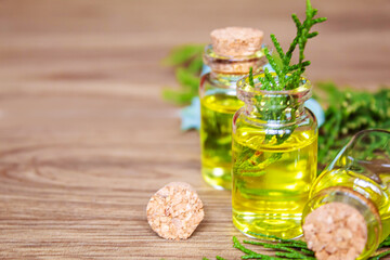 Juniper essential oil in a small bottle. Selective focus.