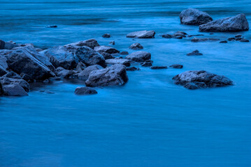 Mountain River. Stones and blue water on a long shutter speed.