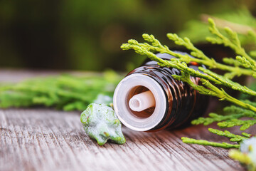 Juniper essential oil in a small bottle. Selective focus.
