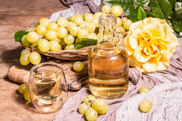 White wine and grape in a wicker basket on wooden table
