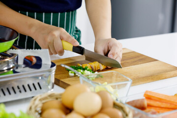 Cropped photo of kid learn to cook healthy food for family in modern home kitchen by using knife...