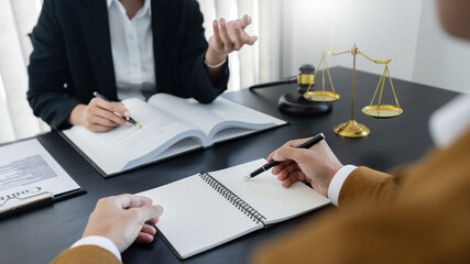 law,libra scale and hammer on the table, 2 lawyers are discussing about legal provision, law...