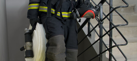 fireman, holding water handling equipment, barrel and hoses