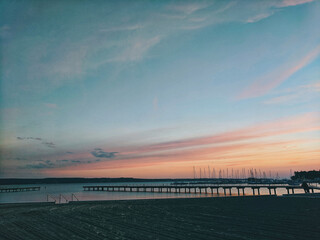 Obraz premium Scenic view to the amazing red sunset at the Adriatic sea, coast in Slovenia at summer. View to green hills with palms and olive trees. Natural backgrounds.