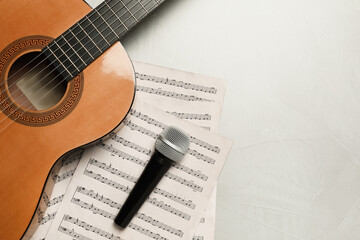 Composition with guitar and music notations on light table, flat lay. Space for text