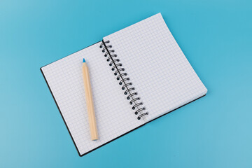 Blank paper and pencil on a blue background