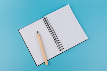 Blank paper and pencil on a blue background