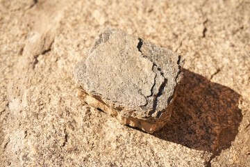 Stone podium on a beige background for a natural design concept. Central composition, top view. High quality photo
